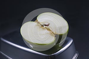 sliced green granny apple on a black background