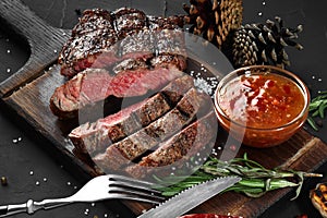 Sliced grilled medium rare beef steak served on wooden board Barbecue, bbq meat beef tenderloin.