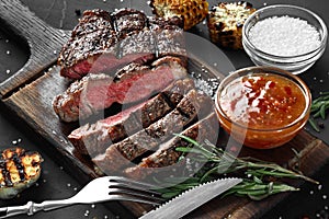 Sliced grilled medium rare beef steak served on wooden board Barbecue, bbq meat beef tenderloin.