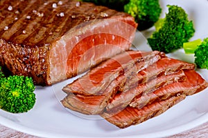 Sliced grilled rare beef steak served with broccoli