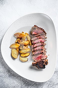 Sliced Grilled rump Beef steak with potato. White background. Top view