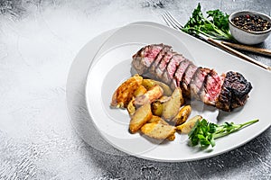 Sliced Grilled rump Beef steak with potato. White background. Top view. Copy space