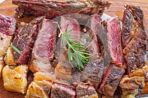 Sliced grilled vaca rubia gallega steak on wooden board with seasonings photo