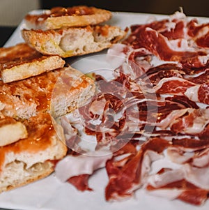 Sliced ??ham and bread on a white plate