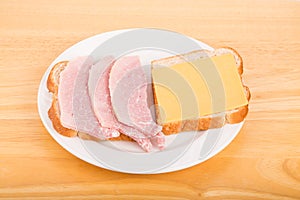 Sliced Ham and Cheese Sandwich on White Plate