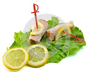 Sliced ham on leaves of salad with lemon