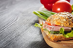 Sliced ham sandwich with tomatoes on a mixed seed bread