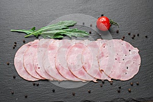 Sliced ham sausage on a stone background