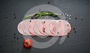 Sliced ham sausage on a stone background