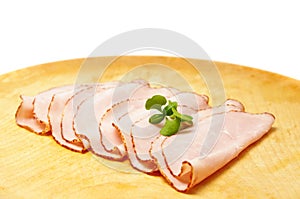 Sliced ham on wooden plate