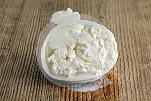 Sliced head of typical Italian cow milk cheese Burrata on a wooden background.