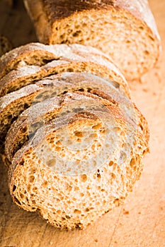 Sliced homemade bread on the wooden cutting board. Selective focus. Shallow depth of field