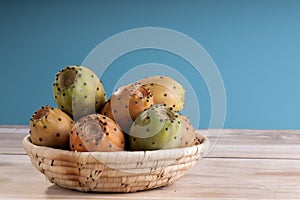 Sliced Indian Figs in a Bowl on White Wood photo