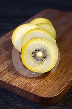 Sliced kiwi fruit on wooden board, close-up of golden kiwi fruit