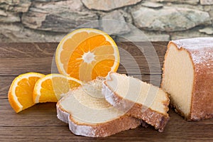 Sliced lemon cake on a wooden table decorated with some pieces o