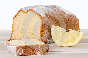 Sliced lemon cake on a wooden table, isolated on white