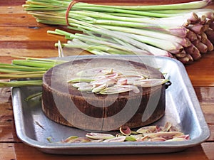 Sliced lemon grass on a wooden cutting board in the tray