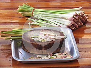 Sliced lemon grass on a wooden cutting board in the tray