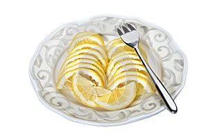 Sliced lemon on a plate on an isolated white background