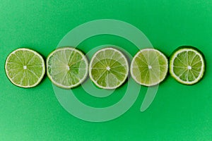 Sliced limes on a green background