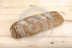 Sliced loaf of bread lying on a wooden table
