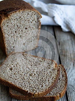 sliced loaf rye bread on a wooden board. Close up. Copy space. Rustic