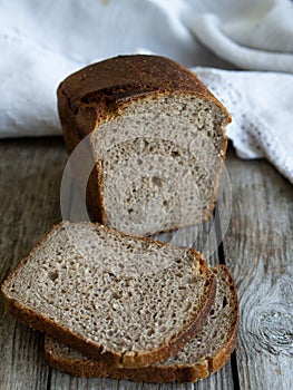 sliced loaf rye bread on a wooden board. Close up. Copy space. Rustic