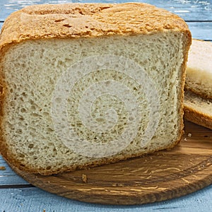 Sliced loaf of white bread on a wooden cutting board.