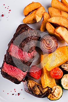 Sliced medium rare grilled Steak Ribeye with french fries