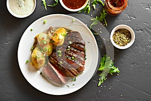 Sliced medium rare roast beef with potatoes