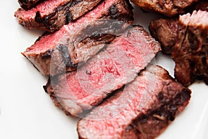 Sliced medium rare steak with blood on a plate close-up. Macro. Defocus