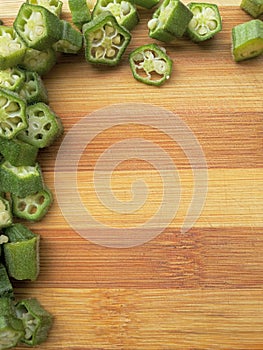 Sliced okra border on wooden background