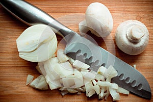 Sliced onion, metal knife and two fungus mushroom