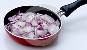 Sliced onions or shallots on frying pan - top view photo