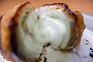 Sliced open fried ice cream scoop on a white plate