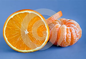 Sliced orange on blue background. Cleared tangerine, closeup