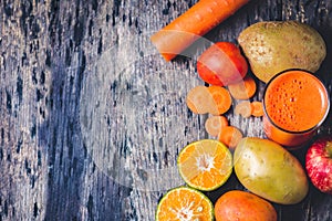 Sliced oranges, carrot, tomato, apple and A glass of mix fruit a