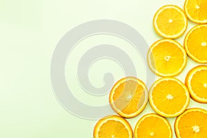 Sliced oranges on green background, top view