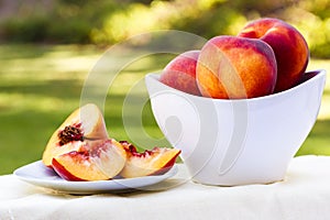 Sliced peach and bowl full of peaches