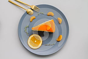 A sliced piece of orange cake decorated with fresh orange
