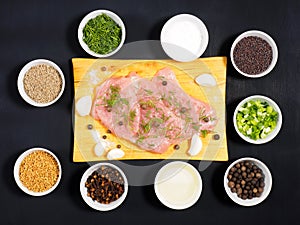 Sliced pieces of meat turkey game filet on a wooden cutting board, garlic, cumin jeera, salt, fennel, allspice, fenugreek,