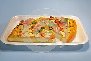 Sliced pieces of pizza in plastic packaging on the table.