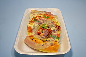 Sliced pieces of pizza in plastic packaging on the table.