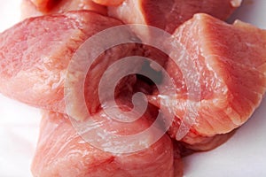 Sliced pieces of raw red meat ready for cooking on a white isolated background close-up