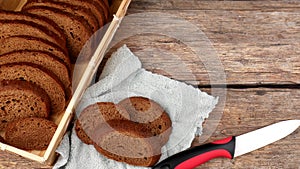 Sliced into pieces rye bread and laid out in a wicker box and three pieces on a towel next to a knife