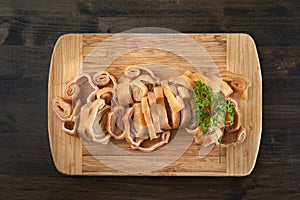 Sliced pigskin on wooden board