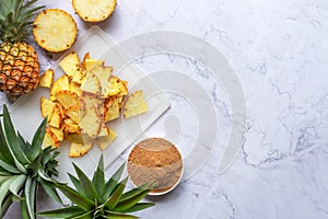 Sliced pineapple on a cutting board with brown sugar preparing to make  home-brew Tepache .