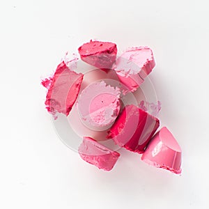 Sliced pink lipstick sample on white background