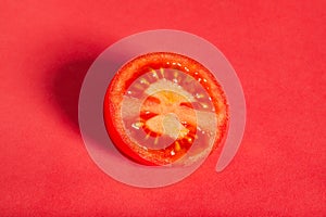Sliced plum tomato on red