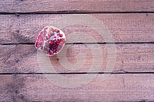 Sliced pomegranate on a wooden background.